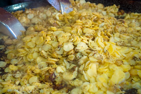 Roasted potatoes with garlic and thyme in big frying pan, street food.の写真素材