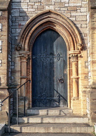 Close-up of traditional gothic medieval wooden entrance door way with ancient brick arcの写真素材