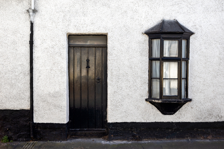 Exterior View of a Beautiful Old English Stone Cottage with door and windowの写真素材
