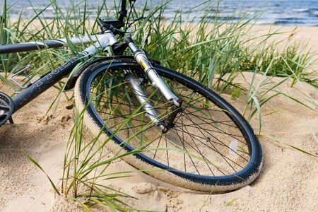 Bicycle left on sandy sea beach trailの写真素材