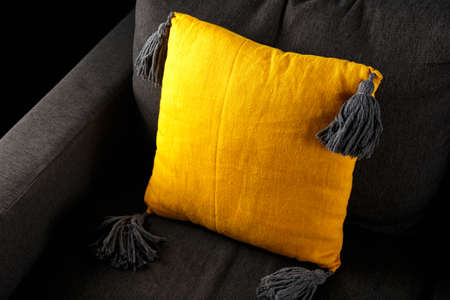 yellow stylish linen Throw pillows with grey macarme boho tassels on couch sofaの写真素材