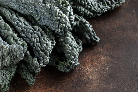 Cavolo nero black curly kale vegetable leaves on dark backgroundの写真素材