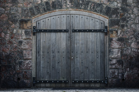 Old arched wooden door and stone facade.の写真素材