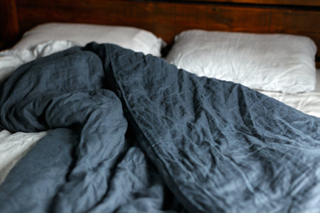 cosy Interior with white bed linen. Bedroom with oak bed, grey and blue bedding, and bedside tableの写真素材