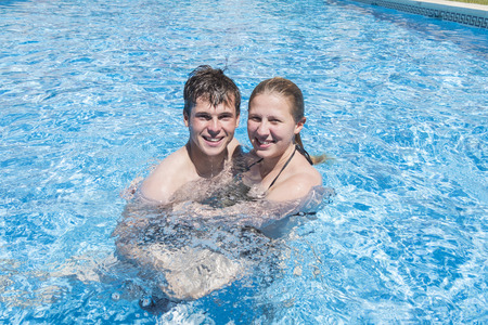 Smiling young couple enjoying the pool in summerの写真素材