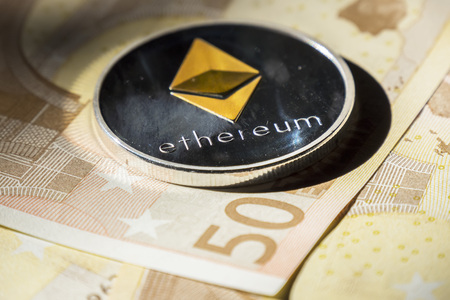 Cryptocurrency coins over euro banknotes; Ethereum coin