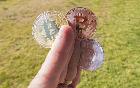 Cryptocurrency coins in a hand; Bitcoinの写真素材