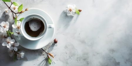 Coffee cup and spring flowers on white background, top view, copy space. Blooming branches of cherry or apple tree and espresso on a white marble tableの素材
