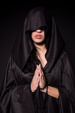 Praying nun, isolated on black backgroundの写真素材