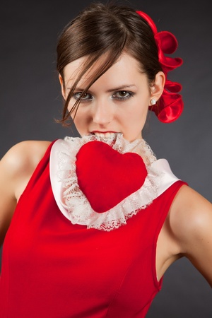 Passion, attractive girl holding heart in mouthの写真素材