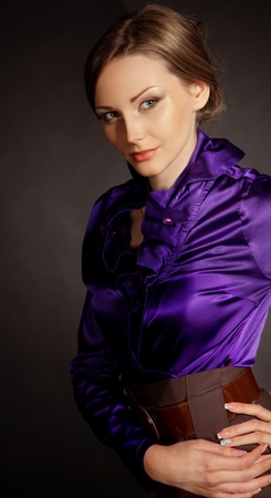 Elegant posing young lady in violet blouseの写真素材