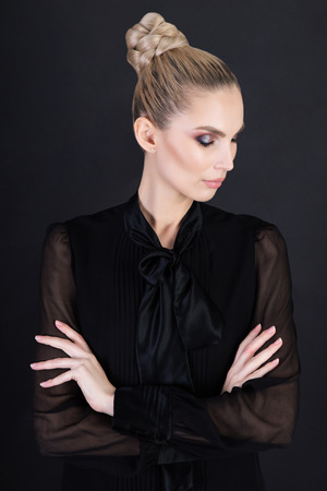 Portrait of thoughtful young business woman in studio over dark backgroundの写真素材