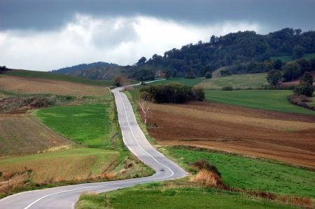 A long road in the Montefeltro s hills, under a stormy skyの写真素材