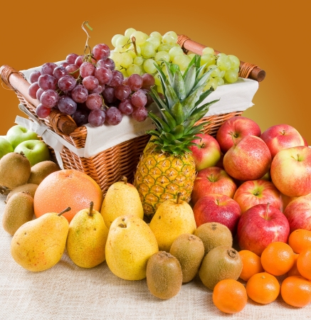 A composition of various fresh fruits with some fruits in a basketの写真素材