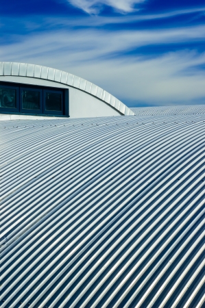 Metallic roof and blue sky with cloudsの写真素材