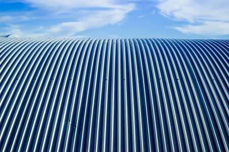 Metallic roof and blue sky with cloudsの写真素材