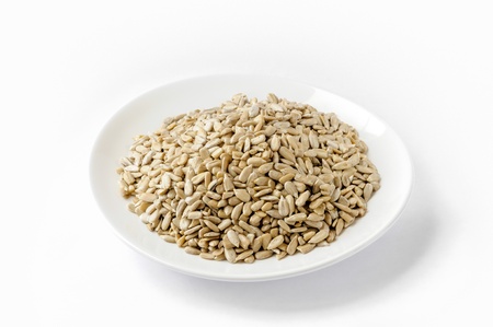 Sunflower seeds in a white plate, on white background