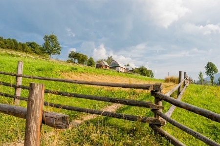 A farm and a field in the ukrainian Carpathian Mountainsの写真素材