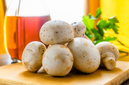 Whole white mushrooms with vinegar and parsley  A window with curtain in the backgroundの写真素材