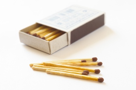 Open matchbox with some matches on a white table