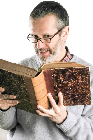 A smiing man reading an old book and wearing glassesの写真素材