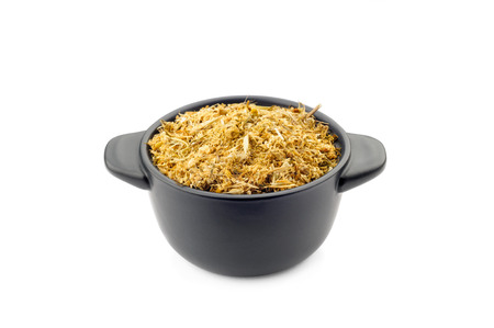 Fragrant natural dry chamomile in a black ceramic dishの写真素材