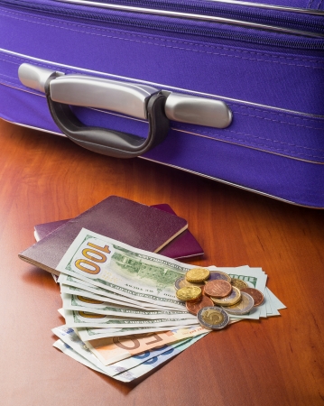 Dollars, Euros and Passports with a violet suitcase, ready for a business or holiday travel abroad.の写真素材