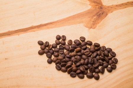 Beans of coffee on a light wooden tableの写真素材