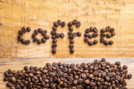 Light wood texture with coffee beans writing the word "coffee"の写真素材