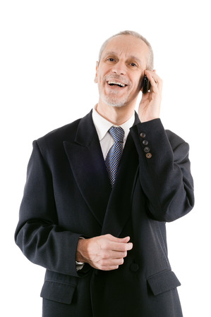A friendly businessman smiling on mobile phoneの写真素材
