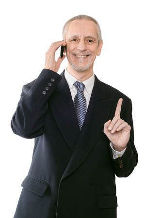 An handsome businessman smiling on mobile phone and showing the forefingerの写真素材