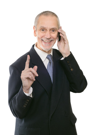 A gentle businessman smiling on mobile phone and showing the forefingerの写真素材