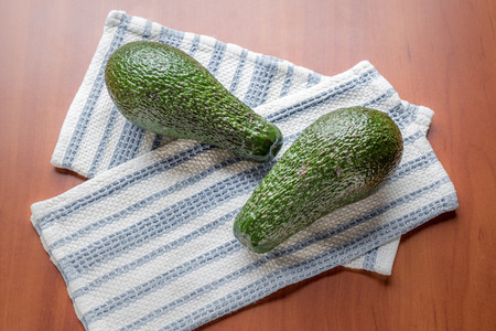 Two green avocados on white and blue napkinsの写真素材