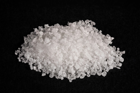 A heap of sea salt on black backgroundの写真素材