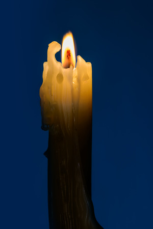 A candle with a flame in the blue nightの写真素材