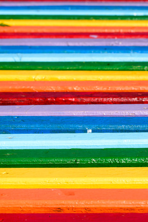 A multicolored wooden bench in the parkの写真素材