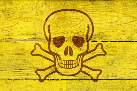 A skull as poison symbol on yellow painted pine planksの写真素材