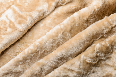 Folds and waves in a warm blond sheepskin Jacket