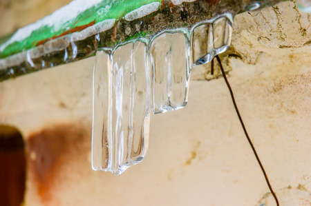 Water stalactites dropping during the cold and gray winter