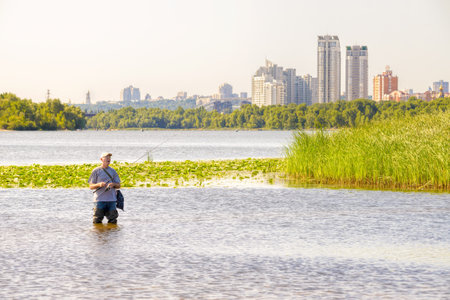 Kiev - Ukraine - July 16, 2014: A fisherman is catching fishes in the Dnieper river close to Kiev,...