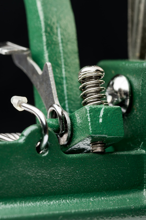 Macro detail of a metallic spring on a cutting machine, on black backgroundの写真素材