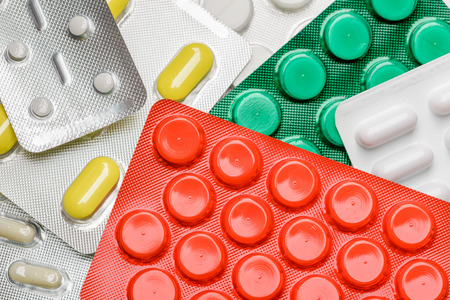 Red, yellow, green and white pills blisters of pharmacy to cure pain and illnessの写真素材