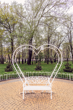 A white heart behind a bench to symbolize love, in the Natalka park of Kiev, Ukraineの写真素材