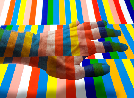 A hand showing a colorful striped background in transparencyの写真素材