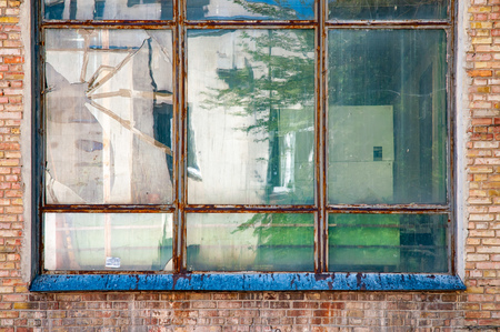 Old metallic window surrounded by red bricks in a soviet building of  Kiev, Ukraine
