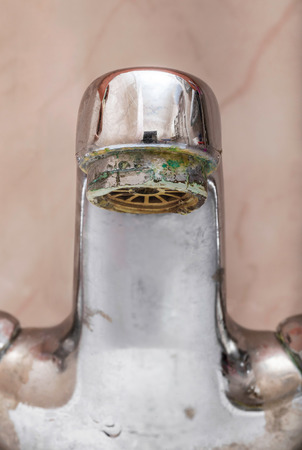 Vertical macro image of closed  tap over a white bathroom sinkの写真素材