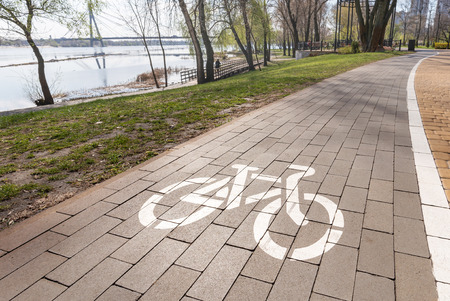 White bike path sign painted on a lane in the Natalka park of Kiev, Ukraineの写真素材