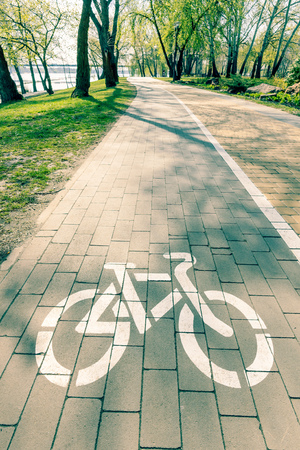 White bike path sign painted on a lane in the Natalka park of Kiev, Ukraineの写真素材