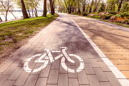 White bike path sign painted on a lane in the Natalka park of Kiev, Ukraineの写真素材