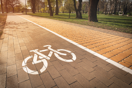 White bike path sign painted on a lane in the Natalka park of Kiev, Ukraineの写真素材